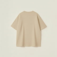 Beige oversized t-shirt for men with white slogan typography and a relaxed drop-shoulder urban fit.
