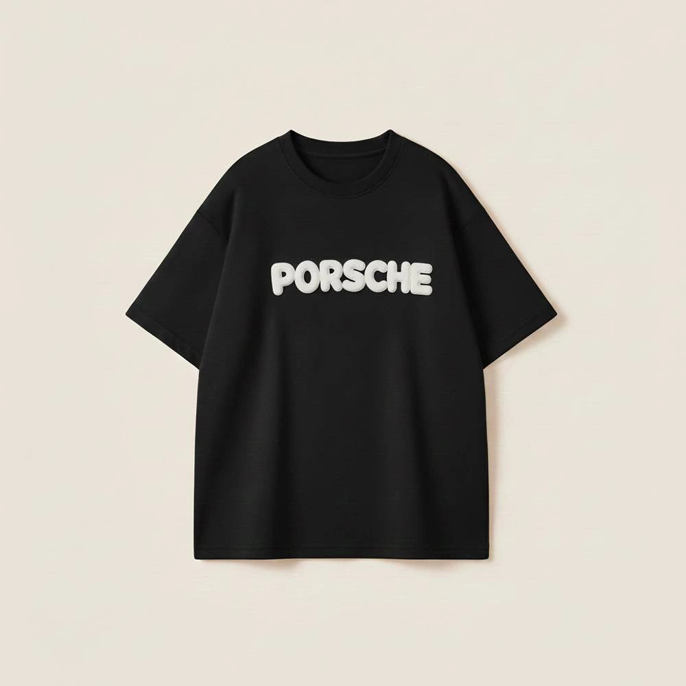 Men’s black oversized cotton t-shirt with white Porsche 3D puff print graphic on the chest.
