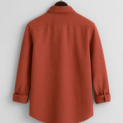 Men's burnt orange textured full sleeve shirt, back view, hanging from a wooden hanger against a white background, showcasing the relaxed fit.