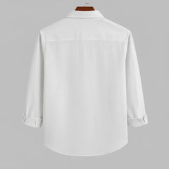 Men's pure white textured full sleeve shirt, back view, hanging on a dark wooden hanger against a light grey background, showcasing the fabric texture and relaxed fit.